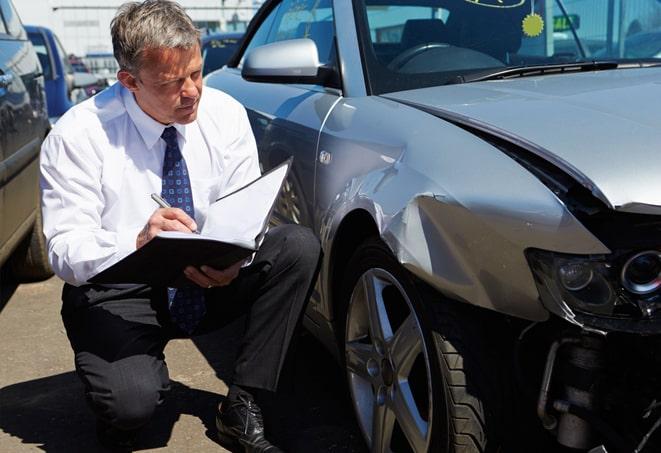 car insurance claim form with pen and calculator